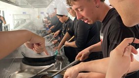 Studierende werden im Umgang mit dem Wok geschult