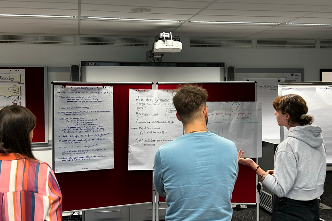 three people discussing in front of a flipchart