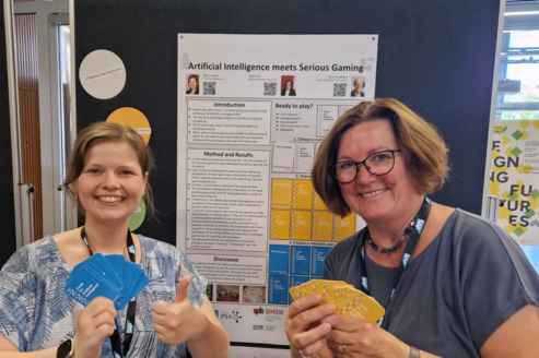 Maria Freese und Birgit Zürn vor dem Poster zu Cards for AI